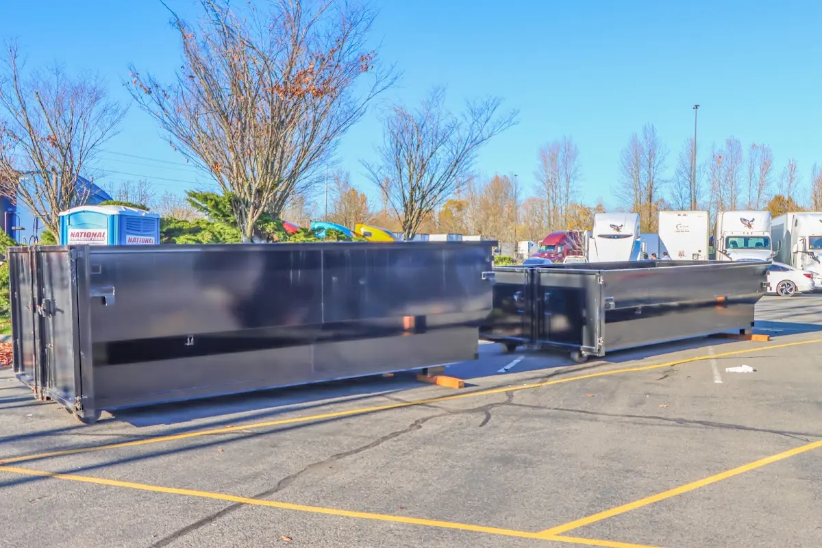 Professional dumpster rental service with roll-off container on residential driveway in Laughlin